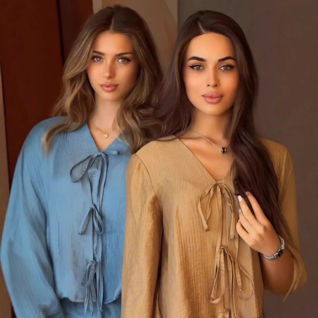 Close-up of the tie-front neckline and wide sleeves on the crinkle satin blouse in teal and khaki