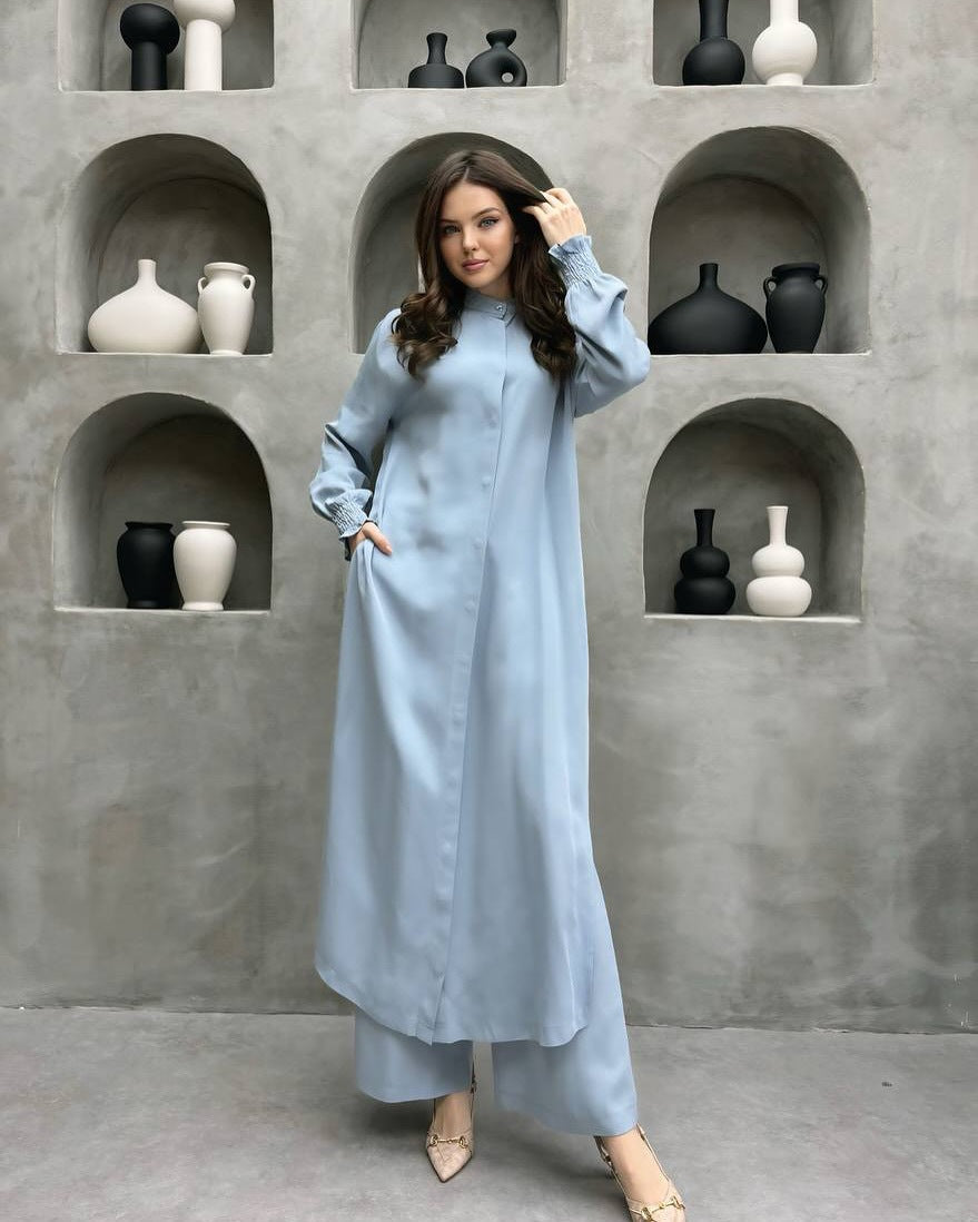 Sky blue long stand-collar shirt and straight-leg trouser set worn full length, styled with the self-tie sash at the waist