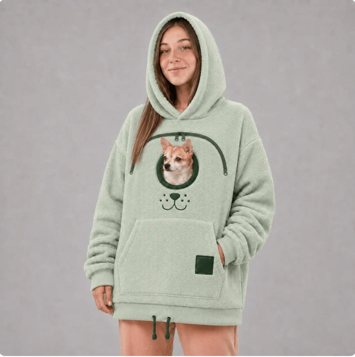 Light green fleece pet carrier hoodie with the dog-face motif below the round pouch opening