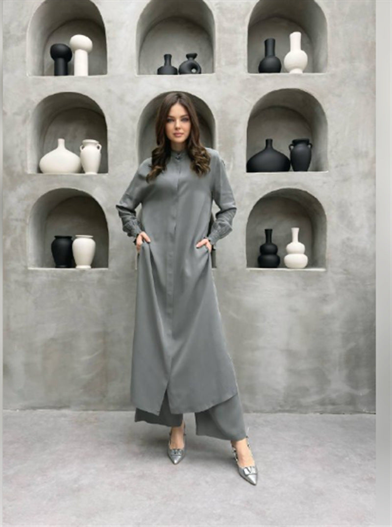 Grey long stand-collar shirt and straight-leg trouser two-piece set worn full length over heels